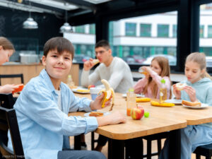 Kinder sitzen in der Schule beim Essen.
